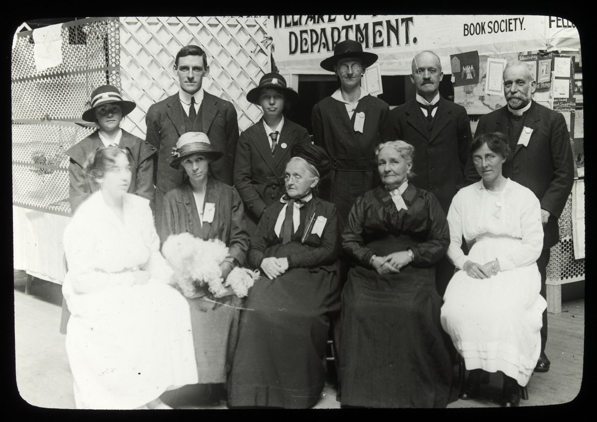 Missions Bazaar, Melbourne Town Hall, group portrait of three men and eight women in front of stall and sign for the Welfare of Youth Department, Melbourne City (1915–24)