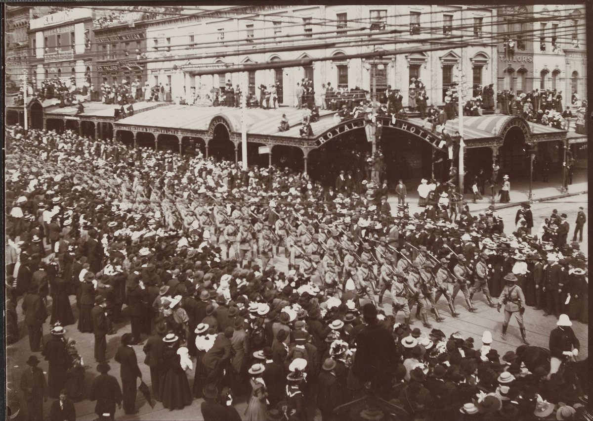 Victorian army contingent, Second Boer War, marching past Royal Mail Hotel, corner Swanston and Bourke streets, Melbourne, Melbourne City (c. 1900)