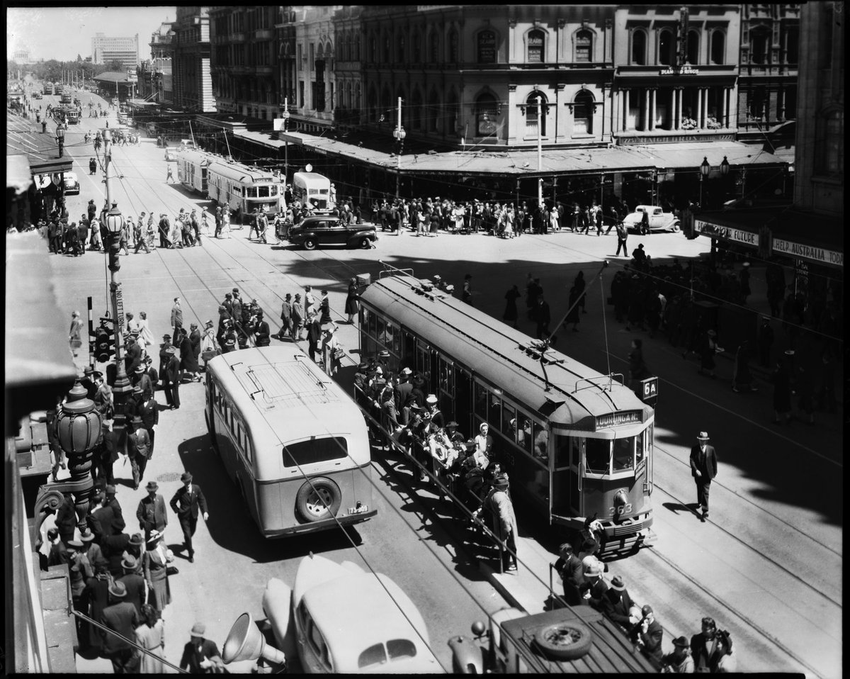Intersection of Swanston and Collins Streets showing trams, a bus and pedestrians, Melbourne City (c. 1943)