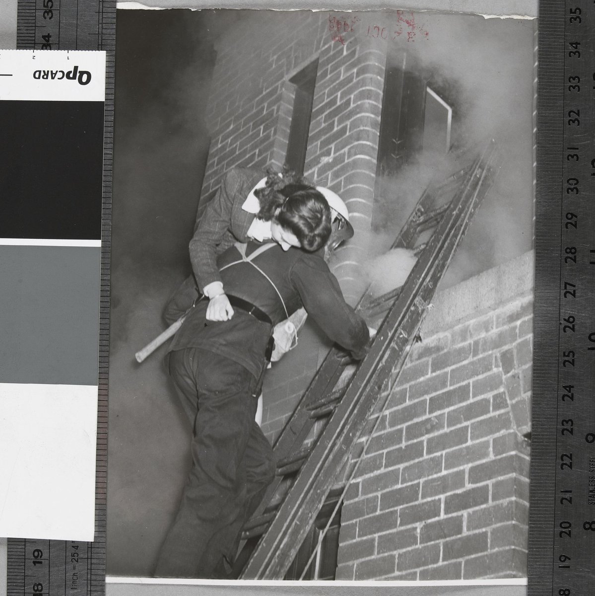 Senior fireman E. J. Goodwin rescues Miss Valerie Milne from a phosphorous fire, Malvern A.F.S. [i.e. Auxiliary Fire Service] (c. 1942)