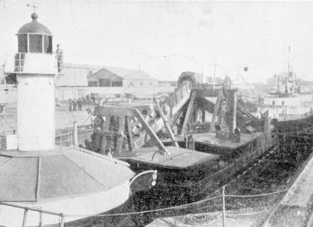 Alfred Graving Dock, Williamstown, showing Lightship, Dredger "Latrobe," and H.M.S. "Cerberus" in Dock. : Strange bedfellows (1885–1946)