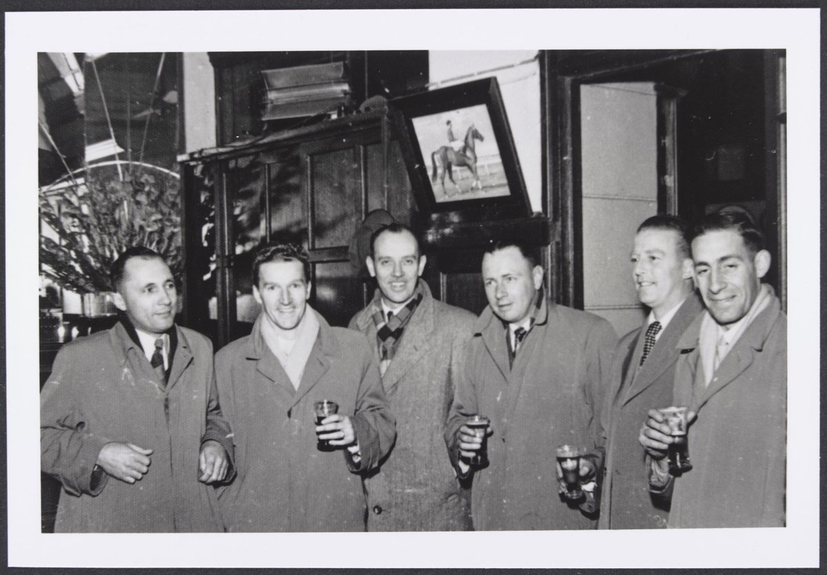 Six members of the Colesanco Table Tennis Club Melbourne Team all wearing overcoats some holding a glass of beer (1954)