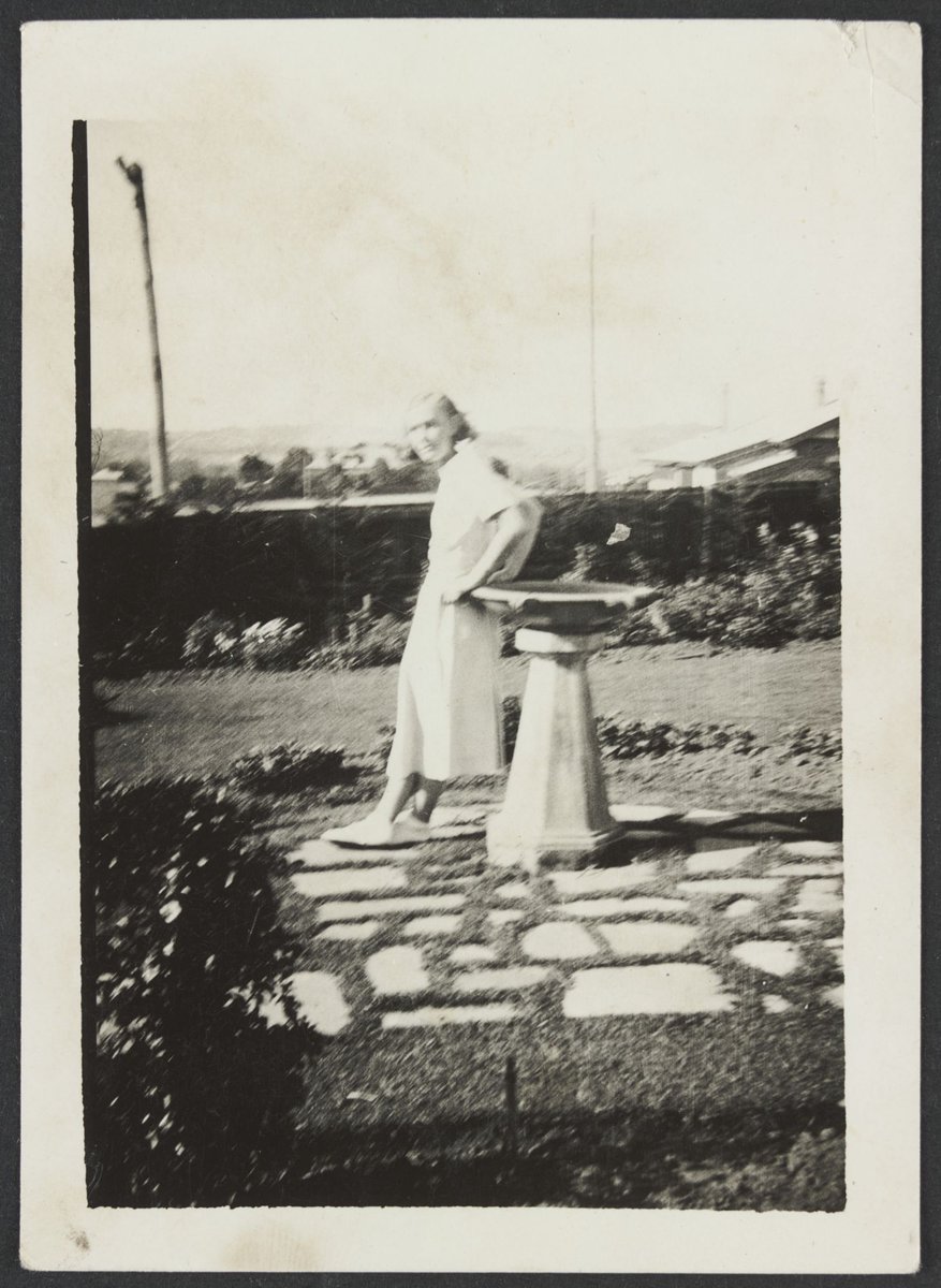 Lorna Williams at E. B. Coles Kew leaning against a sun dial in a garden (1930–40)