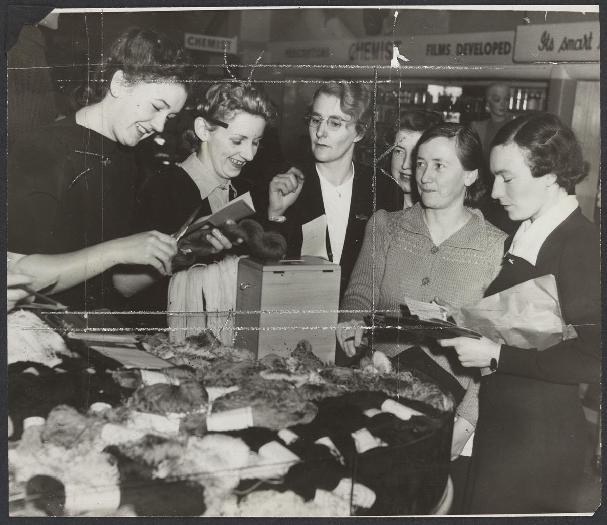 First day of coupon system, women buying skeins of wool using ration books during World War II, Mantons Bourke Street, Melbourne City (1942)