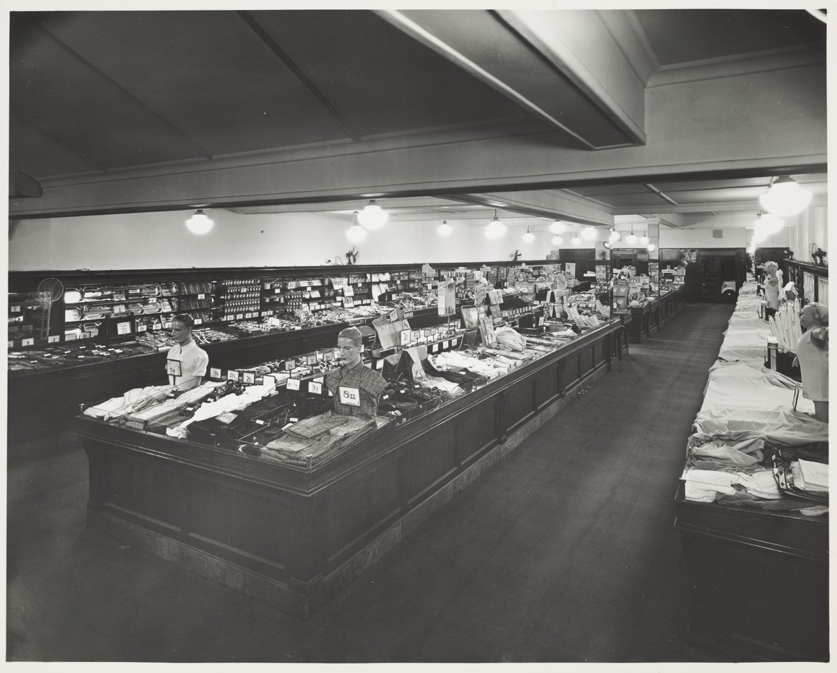 Interior of Coles store with displays for merchandise including check shirts for 8/11 Coburg Store No. 21 (1947)