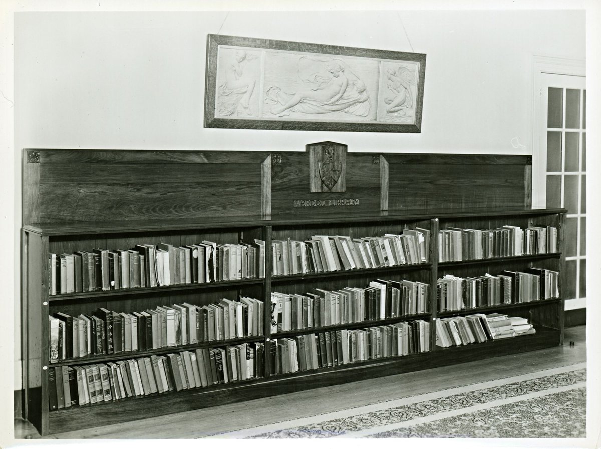 Book case with carved coat of arms and inscription: Verdon Library, probably at Melbourne University, Victoria, Parkville (1920–48)