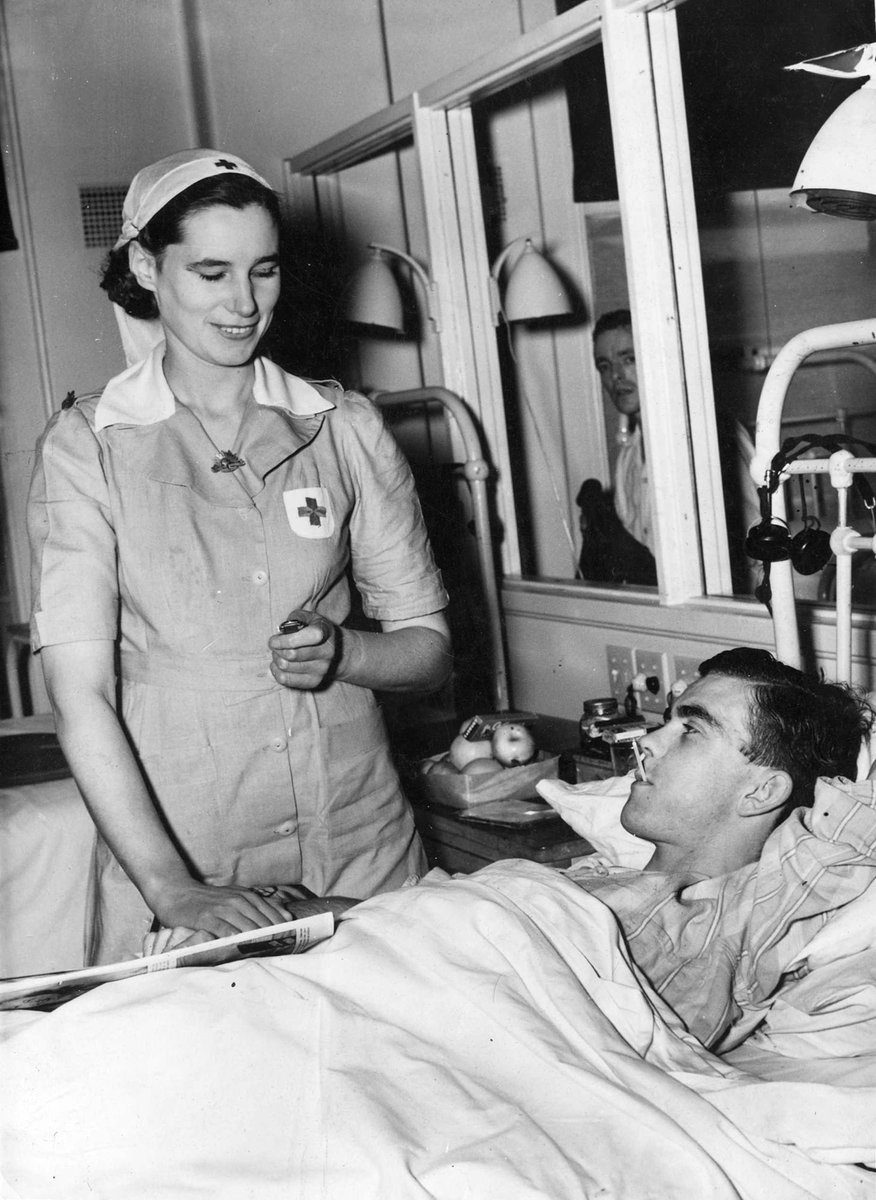 V.A.D. Olive SWASBRICK taking the temperature of Sig. J. F. Peters at a Military Hospital [Heidelberg] (c. 1942)