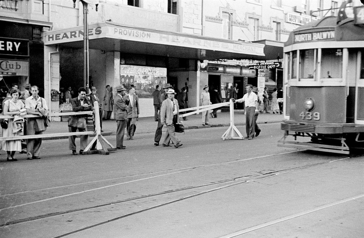 Queen's visit showing crowds at the corner of Flinders and Swanston Streets with barriers erected, Melbourne City (1954)
