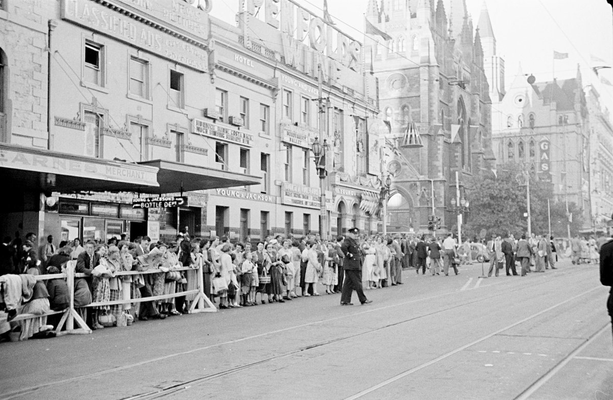 Queen's visit showing crowds at the corner of Flinders and Swanston Streets with barriers erected, Melbourne City (1954)