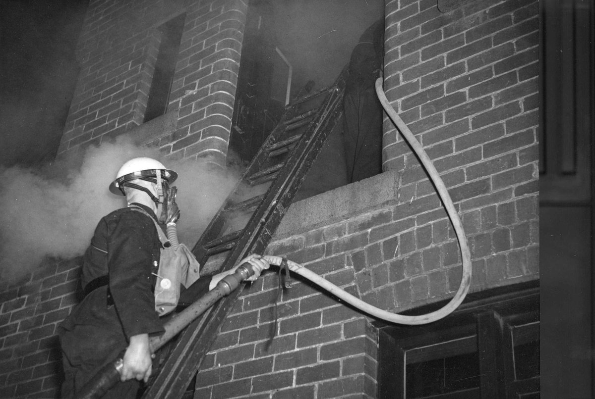 Members of the Malvern A.F.S. [i.e. Auxiliary Fire Service] entering a building with the finishing off hose (1939–45)