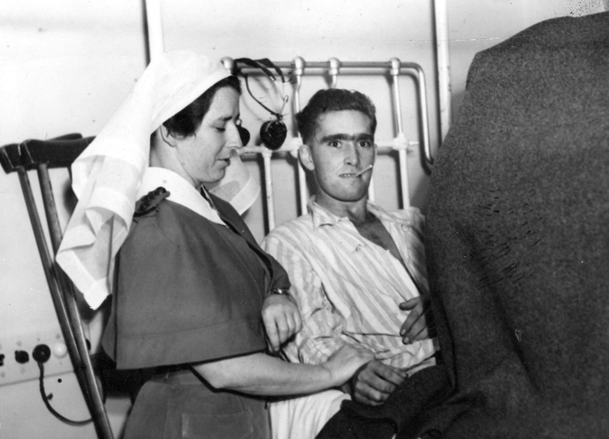 Nurse checking pulse of soldier wounded at Battle of Tarakan, Indonesia at Heidelberg Military Hospital (c. 1945)