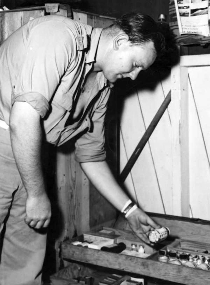 In Korea, Aircraftman OWEN BENNETS OF THORNBURY [Vic.], of the Medical Section of No. 77 Squadron, RAAF, checks the stock of drugs (c. 1952)