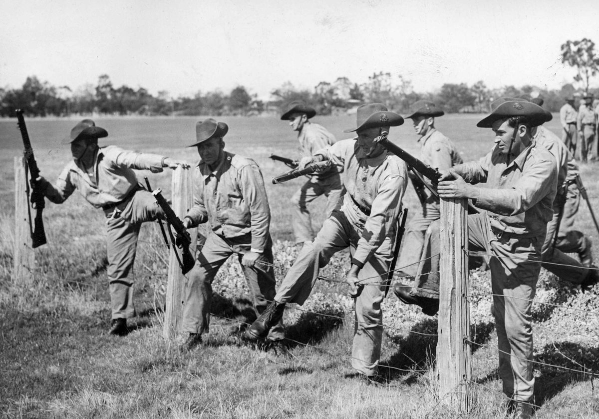 Fences mean nothing to A.I.F. in training at Dandenong (c. 1940)