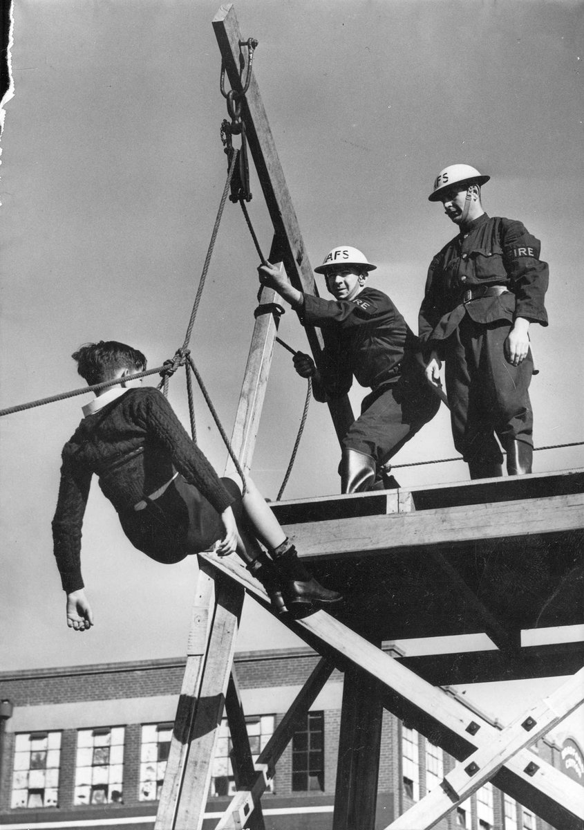 Two Auxiliary Fire Service (Brighton) members in rescue training using a winch (c. 1942)