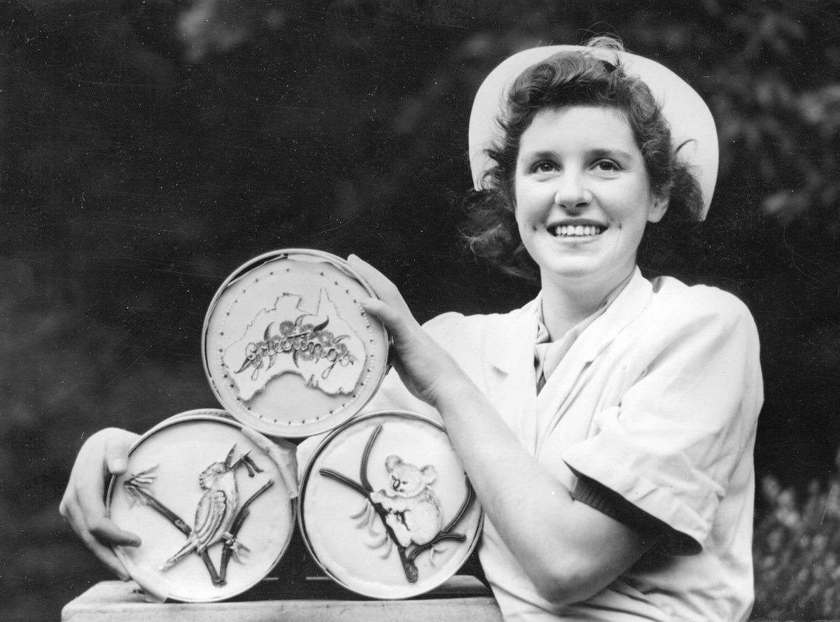 Miss Judith Cook of Murrumbeena with three cakes baked by the Emily Mcpherson College for Britain (c. 1945)
