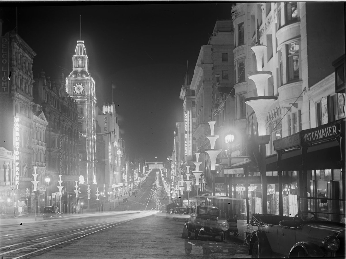 Bourke Street looking east from McKillop Street, showing the Post Office festooned with lights, McEwans illuminated as well as the decorative Centenary street poles illuminated, Melbourne City (1934–35)