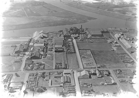 Looking north over Yarra River at Fishermans Bend, factories in foreground including two buildings of General Motors Holden, 1927–38