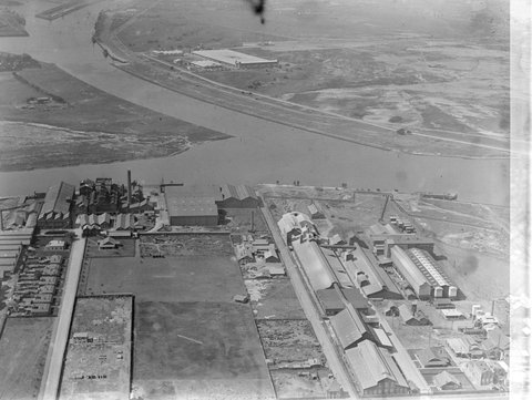 Looking north over Yarra River at Fishermans Bend, factories in foreground including two buildings of General Motors Holden, 1930–35