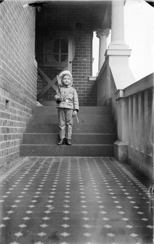 Peggy Cutten dressed as a soldier, on the front steps of "Niantha", Grey Street, St. Kilda, 1910–40