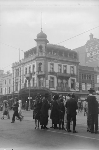 Street scene looking north at Watt's Orient Hotel (260 Bourke Street) on the corner of Bourke and Swanston Streets (east side), 1928