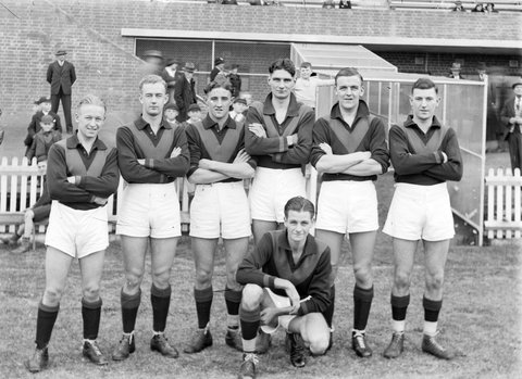 Hawthorn football players in front of a grandstand, 1930s