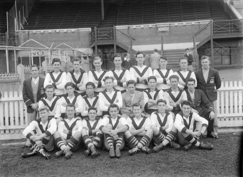 South Melbourne (VFL) football team in front of brick building, c. 1949