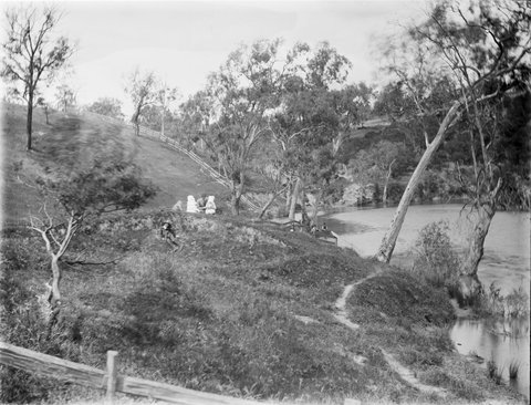 Men fishing, girls in bonnets on hill with pet monkey, possibly at the Yarra, Kew, 1890–1910