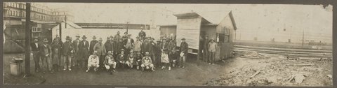 Group of men in workclothes posing in Spencer Street railway yards, c. 1900
