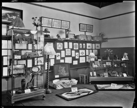 [Display including rugs, needle work and leather work at Brighton Technical School], 1930s