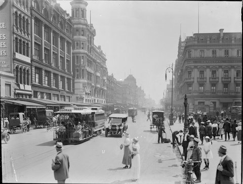Swanston Street, Melbourne, looking north, from beyond Flinders Street, showing cable trams, people, cars and horse drawn vehicles, 1910–20