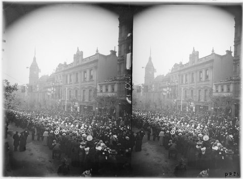 Crowds in Collins Street near Atheneum Theatre, flags across road, 1890–1910