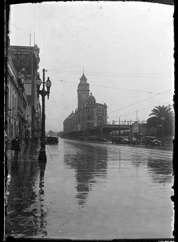 Flinders Street on a wet day, looking east from Queen Street to Flinders Street Railway Station, Melbourne, 1929–35