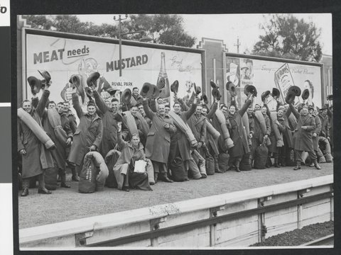 [Crowd of troops at Royal Park railway station, waving their hats, c. 1940