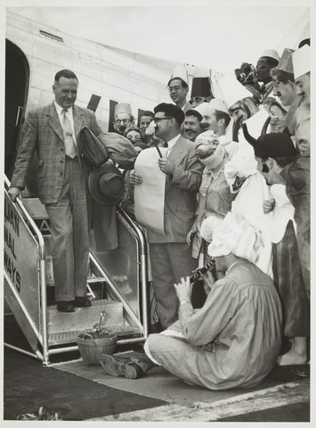Professor Brian Lewis returning to Melbourne from a trip to Turkey, greeted by architecture students in oriental costume, 1951