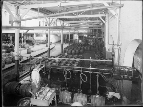 Carlton Brewery interior with casks of Victoria Bitter, racking and loading, 1938
