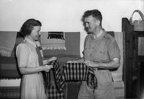 Miss M. Finnin, rehabilitation officer and Sapper W.D. Owen examining scarves woven at the Rockingham Red Cross Convalescent Home, Kew, c. 1943