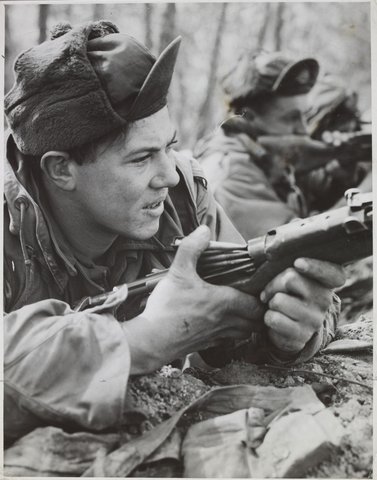 Pte. Cliff Deveney of Coburg (V) loads his rifle during a battle in which Australian took part in Korea, c. 1951