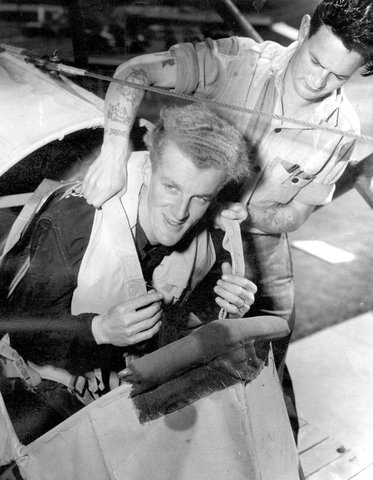 Stages of ditching, Leading Airman Geoff Beardsley, of Mortlake, Vic., being strapped into the cockpit by Naval Airman Jim Welsch of Sunshine, Vic, 1940–45