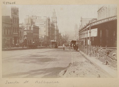 Bourke Street, Melbourne, with building rubble on footpath and cable trams and horse drawn vehicles in street, 1890–1900