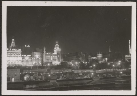 Night view of illuminated buildings in Flinders Street, Melbourne, 1954