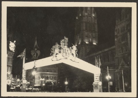Night view of decorative arch over Swanston Street at the corner with Flinders Street, Melbourne, 1954