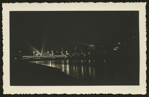 View looking north west across the Yarra River showing Princes Bridge at night, 1930–50