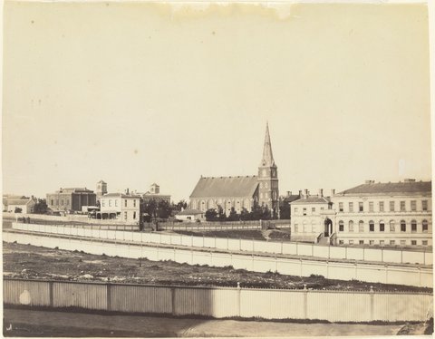 Eastern Hill view of old Printing Office, Chalmer's Church, St. Patrick's College, Scotch College, Unitarian Church etc from Spring St [Melbourne], 1861
