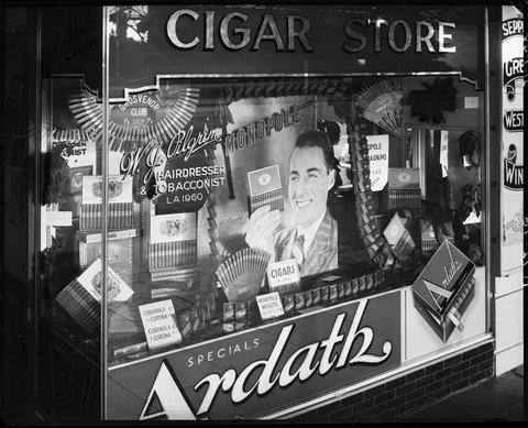 Tobacconist's and barber's display windows, 5 Fitzroy St., St. Kilda, 1948