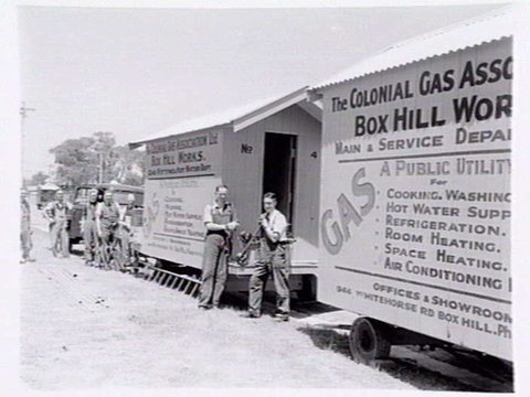 Workmen standing outside two Colonial Gas Association caravans from the Box Hill works, 1937–40