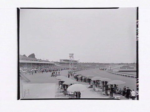 Bird's-eye view of Flemington Racecourse showing people watching race, 1948