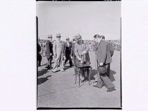 [Officials displaying the Melbourne Cup trophy at Flemington Racecourse, 1949