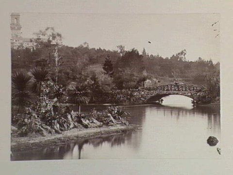 View of rustic bridge and lake, Botanical Gardens, Melbourne. Government House is shown in the background, c. 1890