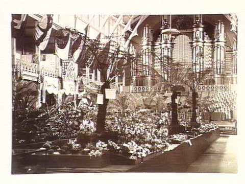 Flower show, Melbourne Exhibition, flowers and tree ferns arranged down centre of hall, 1880–81