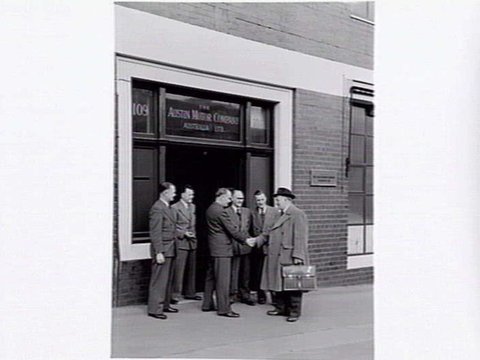 Austin Motor Co., 109 Dudley St., West Melbourne, executives shaking hands, examining car body parts and checking opened crate of body components, 1949
